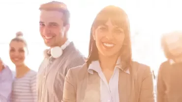 Gruppo di persone sorridenti in un ufficio luminoso.