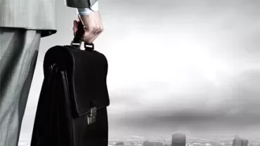 Persona con valigetta guarda la città dall'alto.