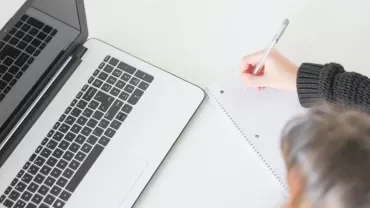 Notebook e laptop su scrivania bianca.