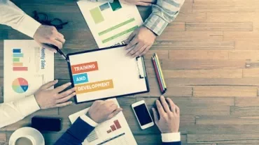 Persone al lavoro su documenti di formazione e sviluppo.