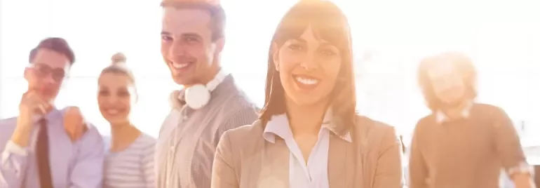 Gruppo di persone sorridenti in un ufficio luminoso.