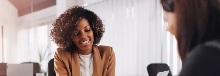 Persone sorridenti sedute a un tavolo in ufficio.