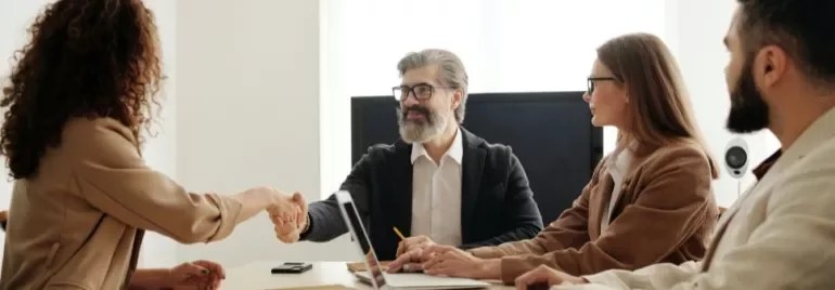 Riunione d'affari con stretta di mano tra due persone.