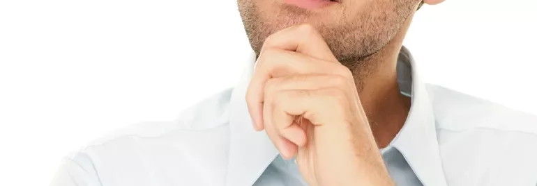 Persona che pensa con mano sul mento, sguardo rivolto in alto.