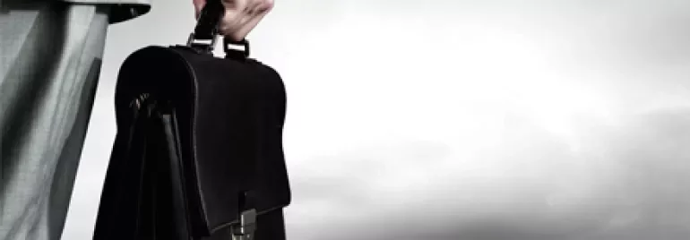 Persona con valigetta guarda la città dall'alto.