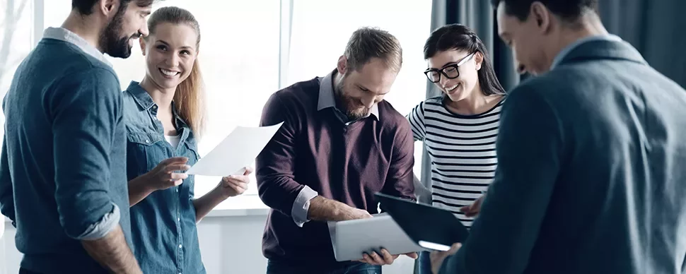 Persone sorridenti che discutono di un progetto con documenti